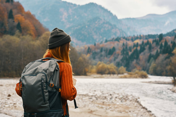 mujer feliz en el bosque de otoño en las montañas al aire libre con una mochila en su turismo de viaje de vuelta - Foto, Imagen