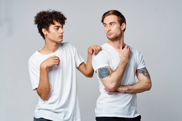 deux hommes en t-shirts blancs sont debout côte à côte fond isolé - Photo, image