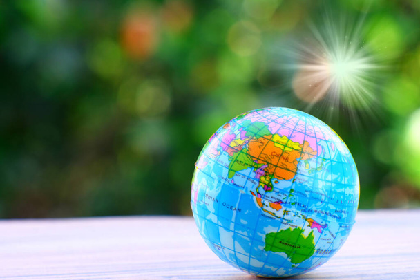 a world globe with an earth and a blurred background of a green planet. - Photo, Image