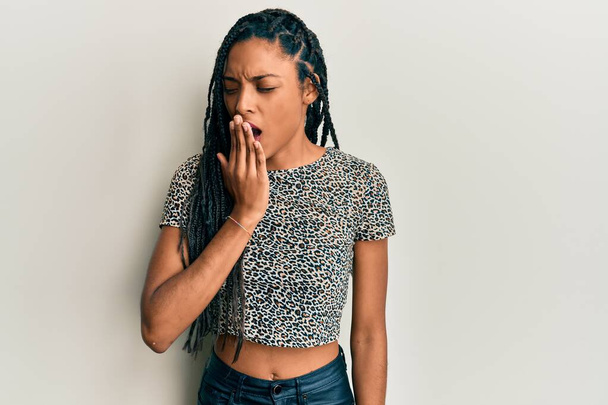 Mujer afroamericana vestida con ropa casual aburrida bostezando cansada cubriendo la boca con la mano. inquietud y somnolencia.  - Foto, imagen