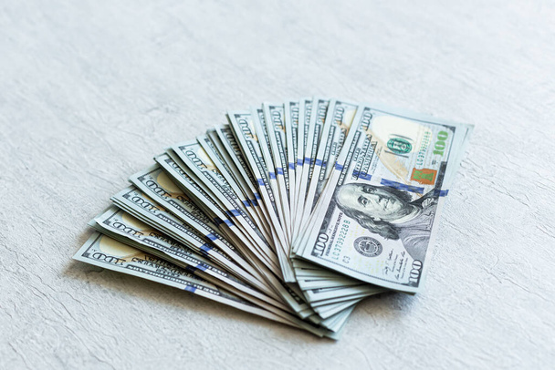 A stack of US dollar bills is folded on a white background.Finance - Фото, зображення