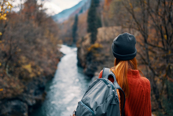 kobieta z plecakiem w przyrodzie na moście w pobliżu rzeki góry przygoda - Zdjęcie, obraz