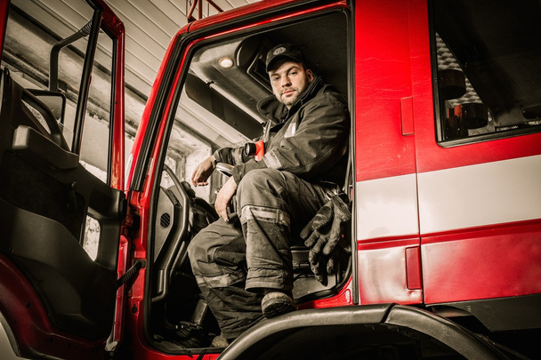 Fireman behind steering wheel of a firefighting truck  - Photo, Image