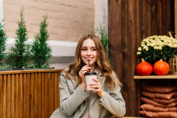 カフェでコーヒーを飲みながら笑顔で電話で話す美しい白人女性 - 写真・画像