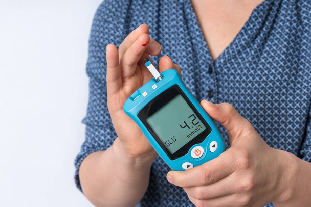 Diyabet hastası kadın kan şekeri seviyesini glikoz ölçer ile ölçüyor. - Fotoğraf, Görsel