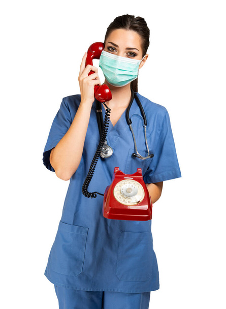 Nurse making a phone call with a vintage telephone covid and coronavirus concept. Isolated on white background - Foto, immagini