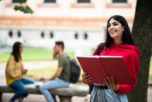University female student reading a book outdoor - Фото, зображення