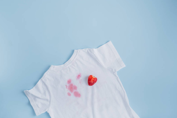 Schmutziger Erdbeerfleck auf weißer Kleidung. Schmutzfleck im Alltag für sauberes und sauberes Konzept. Hochwertiges Foto - Foto, Bild