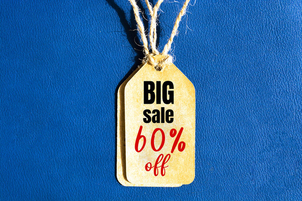 Grote verkoop 60% korting op prijskaartje met bruin koord op blauwe achtergrond - Foto, afbeelding