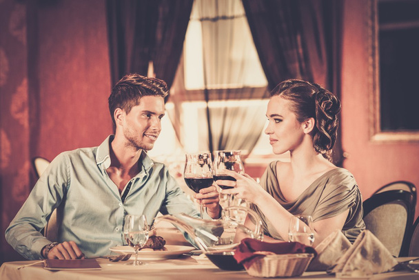 krásný mladý pár se sklenkami vína v restauraci - Fotografie, Obrázek