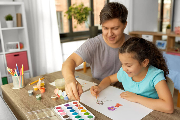 happy father with little daughter drawing at home - 写真・画像
