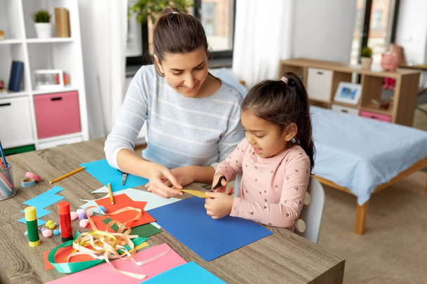 daughter with mother making applique at home - 写真・画像
