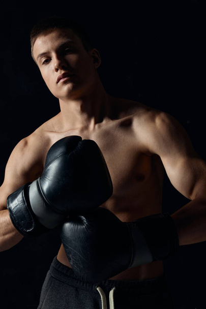 man wearing boxing gloves nude torso black background cropped view model fitness  - Foto, Imagem