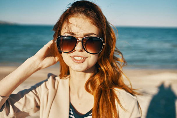 muotokuva punatukkainen nainen lasit lähellä merta vuorilla rannalla rajattu näkymä - Valokuva, kuva