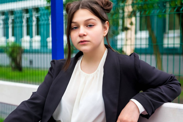 Art noise film style image. Portrait of thirteen-year-old schoolgirl in white blouse, plaid skirt and jacket at school. Emotional teen girl posing looking at camera. Concept of school age and learning - Fotoğraf, Görsel