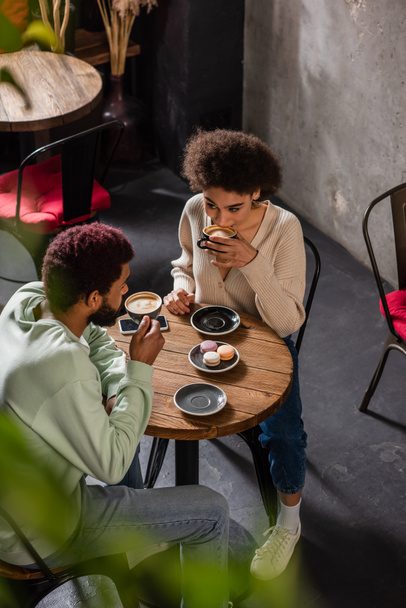 High angle view of african american couple drinking coffee in cafe during date  - Foto, Imagem