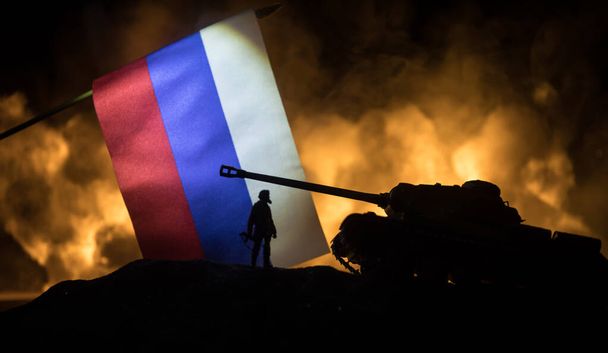 Oroszország zászlót égő sötét háttér. A háború válságáról és a nemzetek közötti politikai konfliktusokról.A katonai sziluettek sötét tónusú háttérrel harcolnak. Szelektív fókusz - Fotó, kép