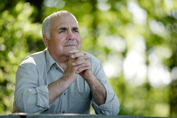 Homme âgé assis dans le jardin pensant
 - Photo, image