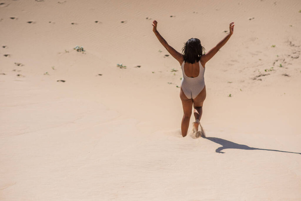 Femme descendant une dune de sable prise par derrière - Photo, image