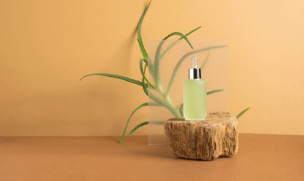 Cosmetics serum oil bottle modern podium of natural colors tropical plant leaf - Photo, Image