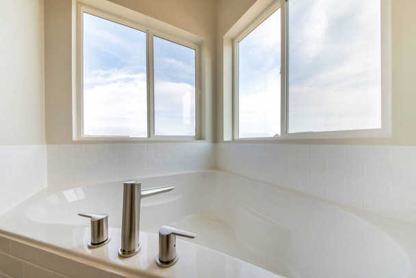 A minimalistic bathroom interior design in white color with a bathtub and windows - Фото, изображение