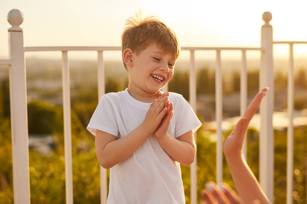 Happy boy playing with parent on terrace - Fotó, kép