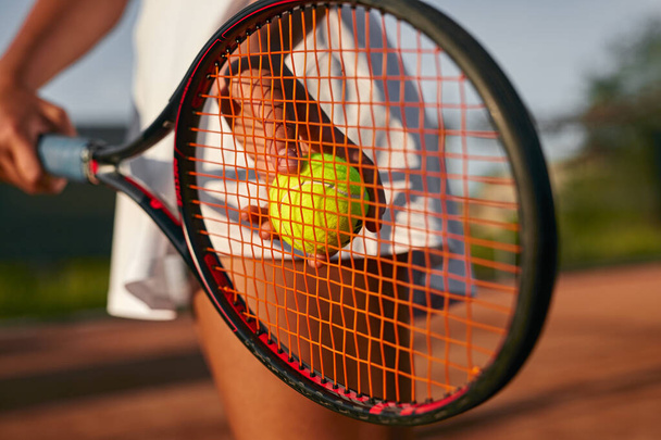 Crop woman playing tennis on court - Foto, afbeelding