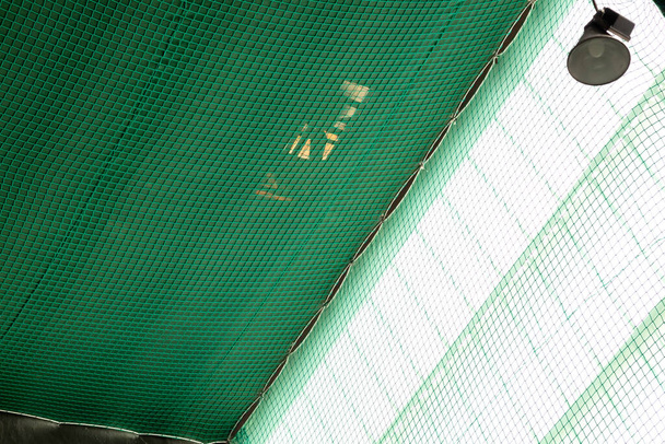 iş sırasında düşme riskini önlemek için çatı altına yerleştirilmiş düzenleyici yeşil renk ağı - Fotoğraf, Görsel