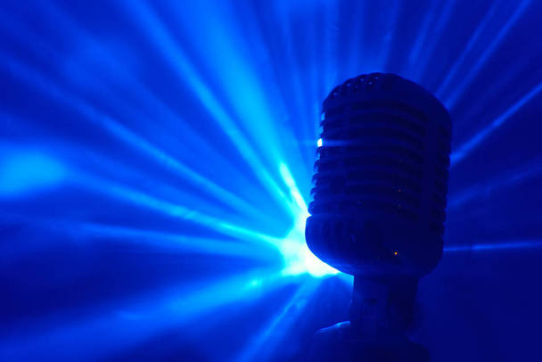 Chanteur tenant un microphone rétro. Performance live ou concept karaoké. - Photo, image
