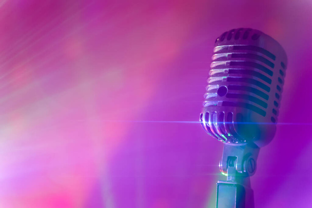 Vintage microfoon met podiumdiscolampen. Live optreden of karaoke concept. - Foto, afbeelding