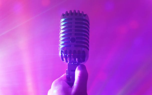 Τραγουδιστής κρατώντας ρετρό μικρόφωνο. Έννοια ζωντανής παράστασης ή καραόκε. - Φωτογραφία, εικόνα
