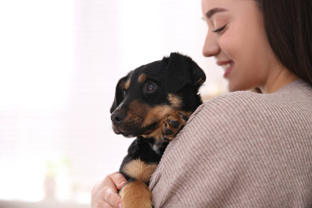 Woman with cute puppy on light background. Lovely pet - Фото, изображение