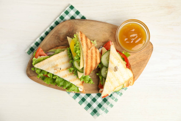 Νόστιμα σάντουιτς με λαχανικά και τυρί σε λευκό τραπέζι, top view - Φωτογραφία, εικόνα
