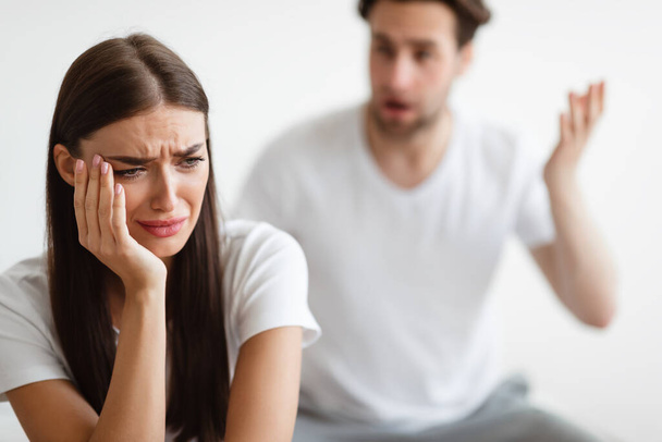 Ehefrau weint, während aggressiver Ehemann sie im Schlafzimmer anschreit - Foto, Bild