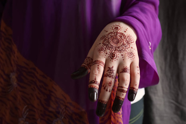 Woman with henna tattoo on hand, closeup. Traditional mehndi ornament - Foto, afbeelding