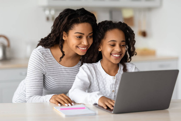 Smiling african american mom helping her studying kid, copy space - Foto, Imagem