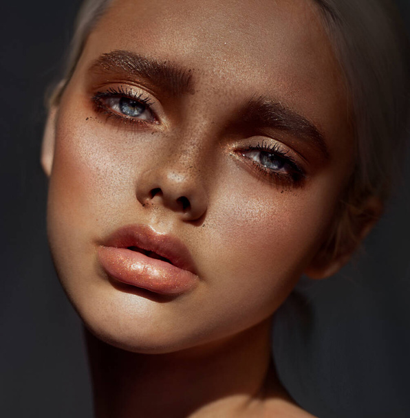 Portrait of a girl. Close-up of a woman's face. Freckles on the face. Artistic retouching. Plump lips. Glare in the eyes. - Foto, imagen