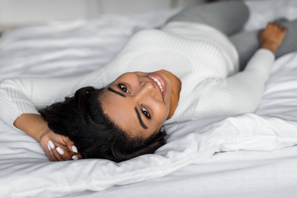 Gelukkig jong Afro-Amerikaans vrouw poseren na wakker worden - Foto, afbeelding