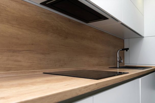 Modern mutfak içi indüksiyon hob ve lavabolu musluk. - Fotoğraf, Görsel