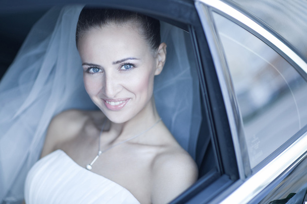 Attractive caucasian bride sitting in car and smile to the camera - Photo, Image