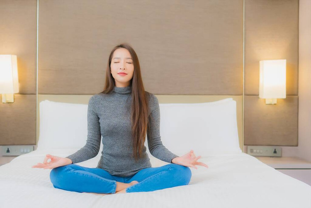 Portrait beautiful young asian woman meditation on bed in bedroom interior - Photo, Image