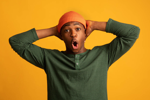 Portrait de noir hipster Guy ouverture bouche et toucher la tête en étonnement - Photo, image
