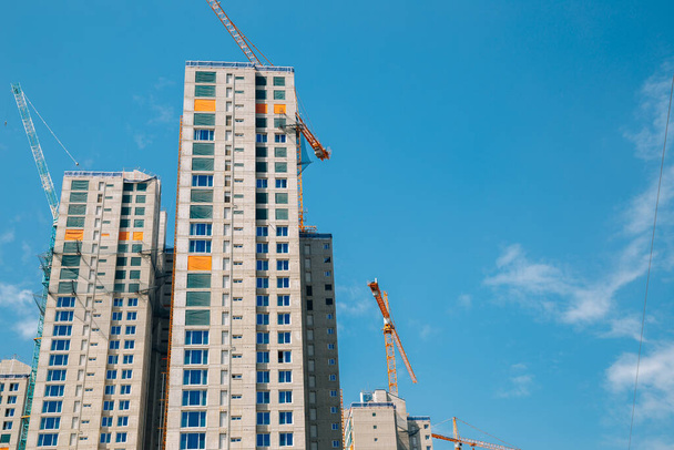 Modern apartment building with crane on construction site - Fotó, kép