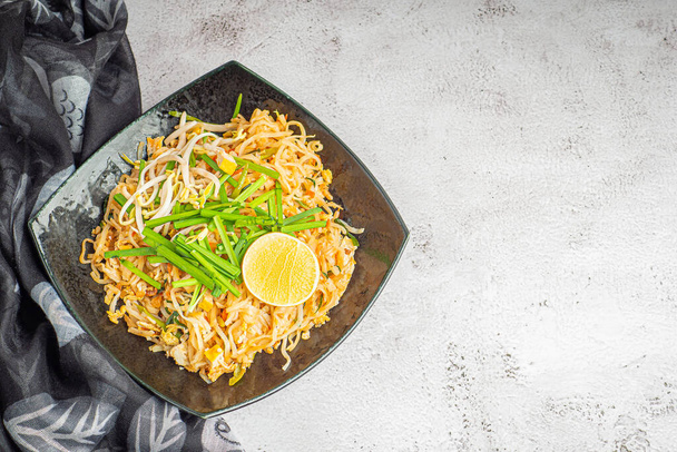 Падтайська кухня подається з овочами та лимонними скибками в чорній страві на сірому цементі. Таїландська їжа відома. Верхній вид з копіюванням простору. Концепція тайської традиційної їжі - Фото, зображення
