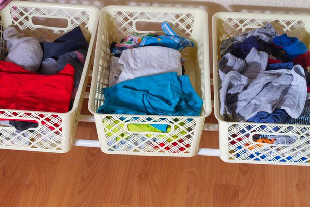 Clothes in containers for clothes in the wardrobe at home. - Foto, imagen