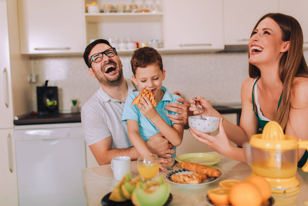 Щаслива сім'я снідає вдома за кухонним столом
. - Фото, зображення