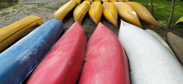 Canoas de plástico en fila sin paletas como concepto de campamento de verano - Foto, imagen