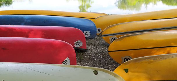 Canoas en la orilla esperando a los niños en el campamento de verano - Foto, imagen