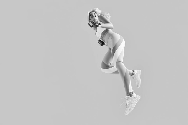 Sportswoman jumping and stretchin - Fotografie, Obrázek