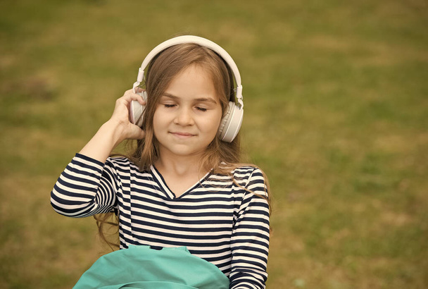 Bring music to life. Little child listen to music with closed eyes. Small girl wear headphones playing music. New technology. Modern life. Fun and entertainment. Press play and enjoy, copy space - Фото, изображение